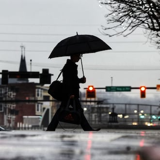 A man holds an umbrella as he crosses High Street in the rain Wednesday morning, Jan. 24, 2024 in Hamiilton. NICK GRAHAM/STAFF