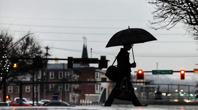 A man holds an umbrella as he crosses High Street in the rain Wednesday morning, Jan. 24, 2024 in Hamiilton. NICK GRAHAM/STAFF