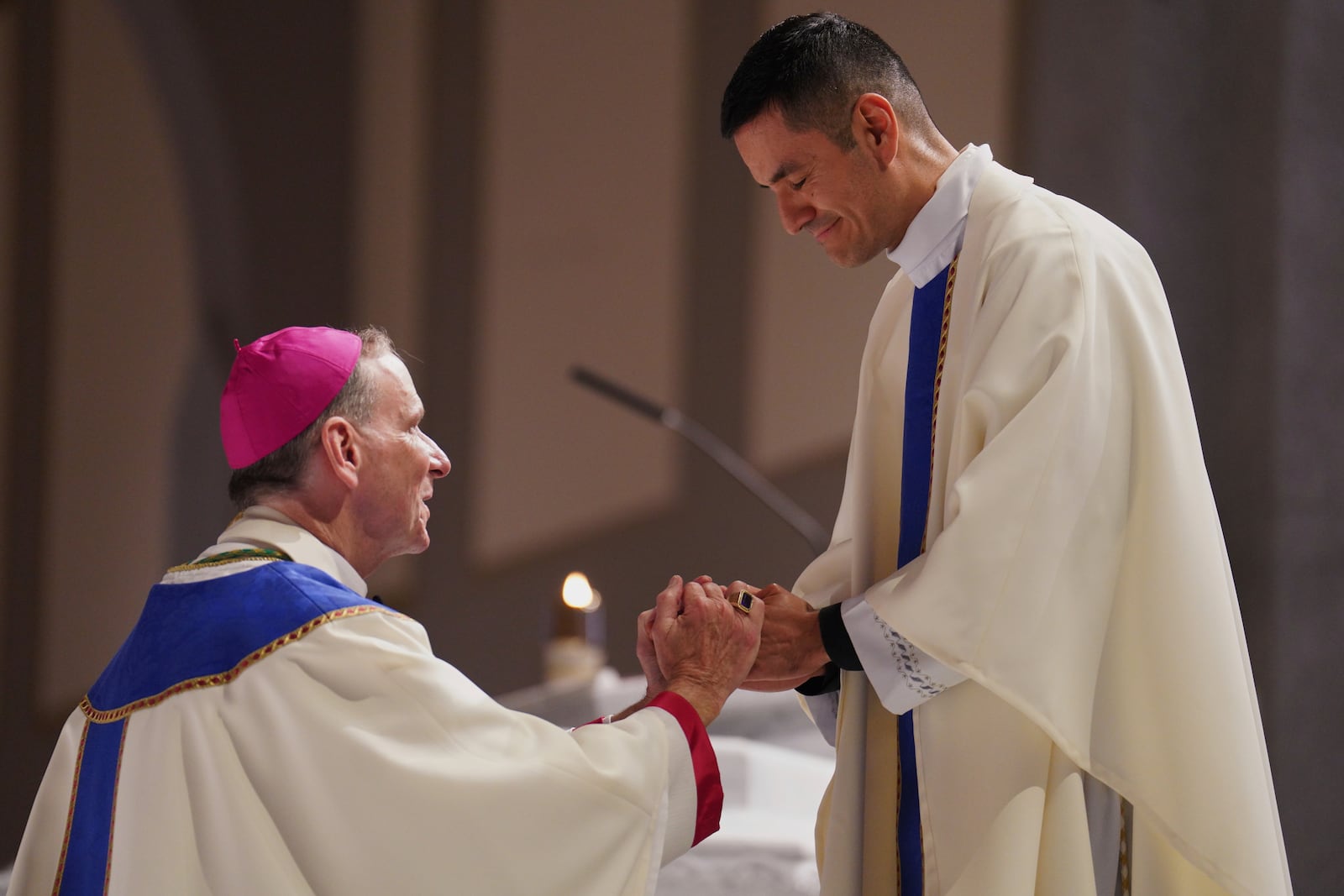 The Rev. Alfredo Tuesta gives his first blessing as a newly ordained priest to Bishop Michael Burbidge, who leads the Diocese of Arlington, at the Cathedral of Saint Thomas More in Arlington, Va., on Saturday, June 7, 2025. (AP Photo/Jessie Wardarski)