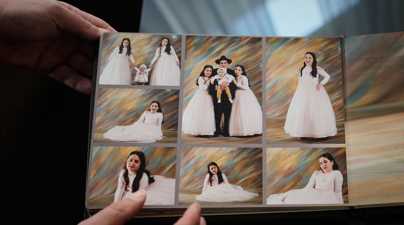 A relative shows photos of three siblings, Yaakov Biton and his two sisters, Avigail and Sarah, who were killed earlier this week when an Iranian missile struck their home in the city of Beit Shemesh, Jerusalem, Thursday, March 5, 2026. (AP Photo/Ohad Zwigenberg)