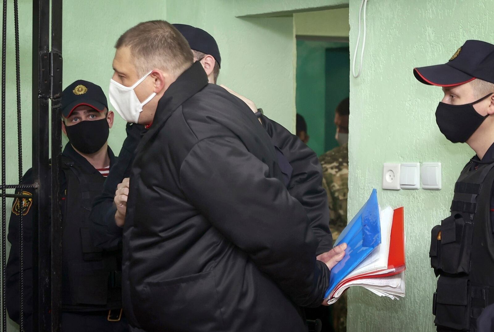 FILE - Blogger Siarhei Tsikhanouski, centre, stands outside a cage in a courtroom in remand prison in Gomel, Belarus, Tuesday, Dec. 14, 2021. (Sergei Kholodilin/BelTA via AP, File)