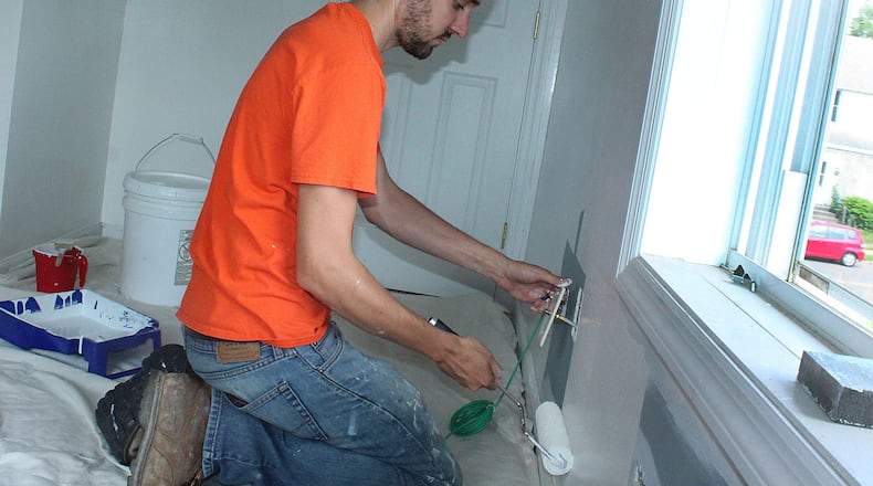 Alex Sheridan of Marion Ohio helps paint a bedroom in a house being rehabbed in Springfield. JEFF GUERINI/STAFF