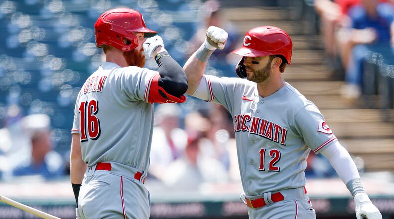Cincinnati Reds' Tyler Naquin (12) celebrates with Colin Moran (16) after hitting a solo home run against the Cleveland Guardians during the fifth inning of a baseball game, Thursday, May 19, 2022, in Cleveland. (AP Photo/Ron Schwane)