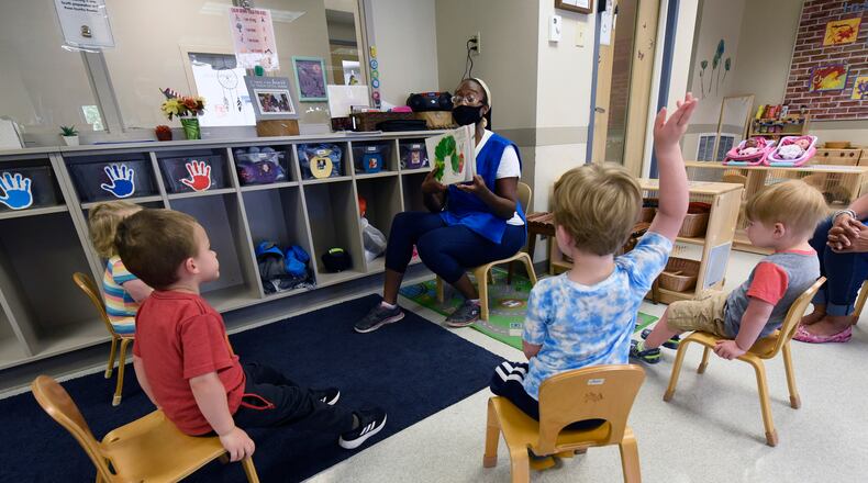 Valissa Williams, assistant teacher, Child Development Center, Wright-Patterson Air Force Base, reads a book to toddlers in August 2020. (U.S. Air Force photo/Ty Greenlees)