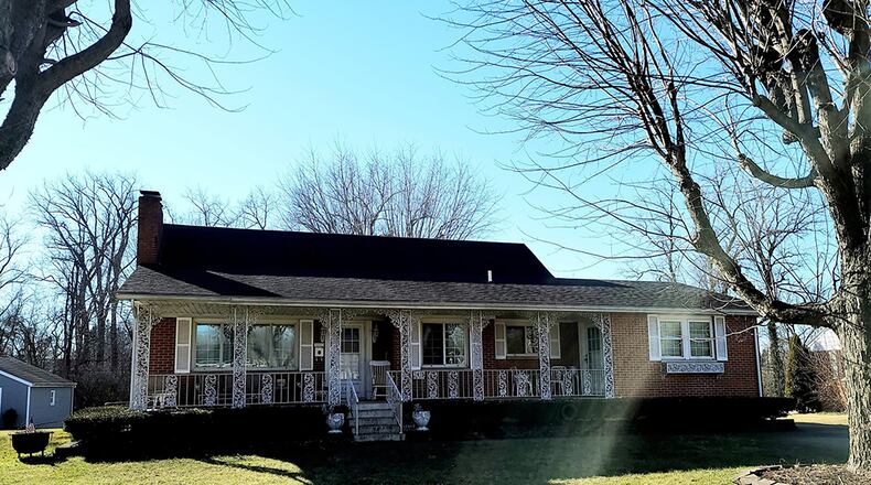 The 4-bedroom, Cape Cod-style home has about 2,240 sq. ft. of living space. The home features a long covered front porch with decorative wrought iron railings and a concrete floor. CONTRIBUTED PHOTO