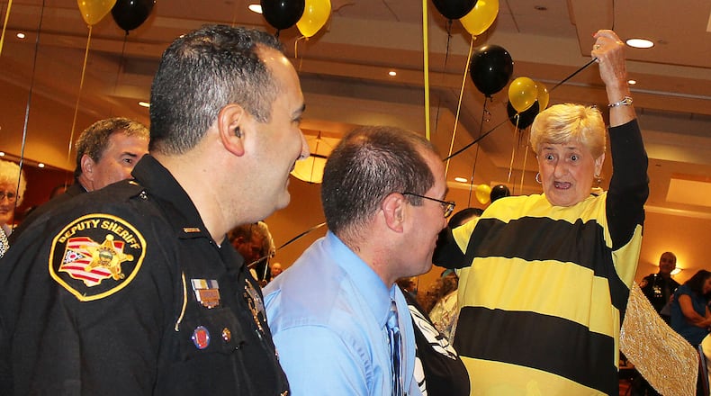 Artrusa International of Springfield member, (right) Linda Howell gets ready to pop the balloons of the team after they misspelled a word in the 19th annual Literacy Sting. JEFF GUERINI/STAFF