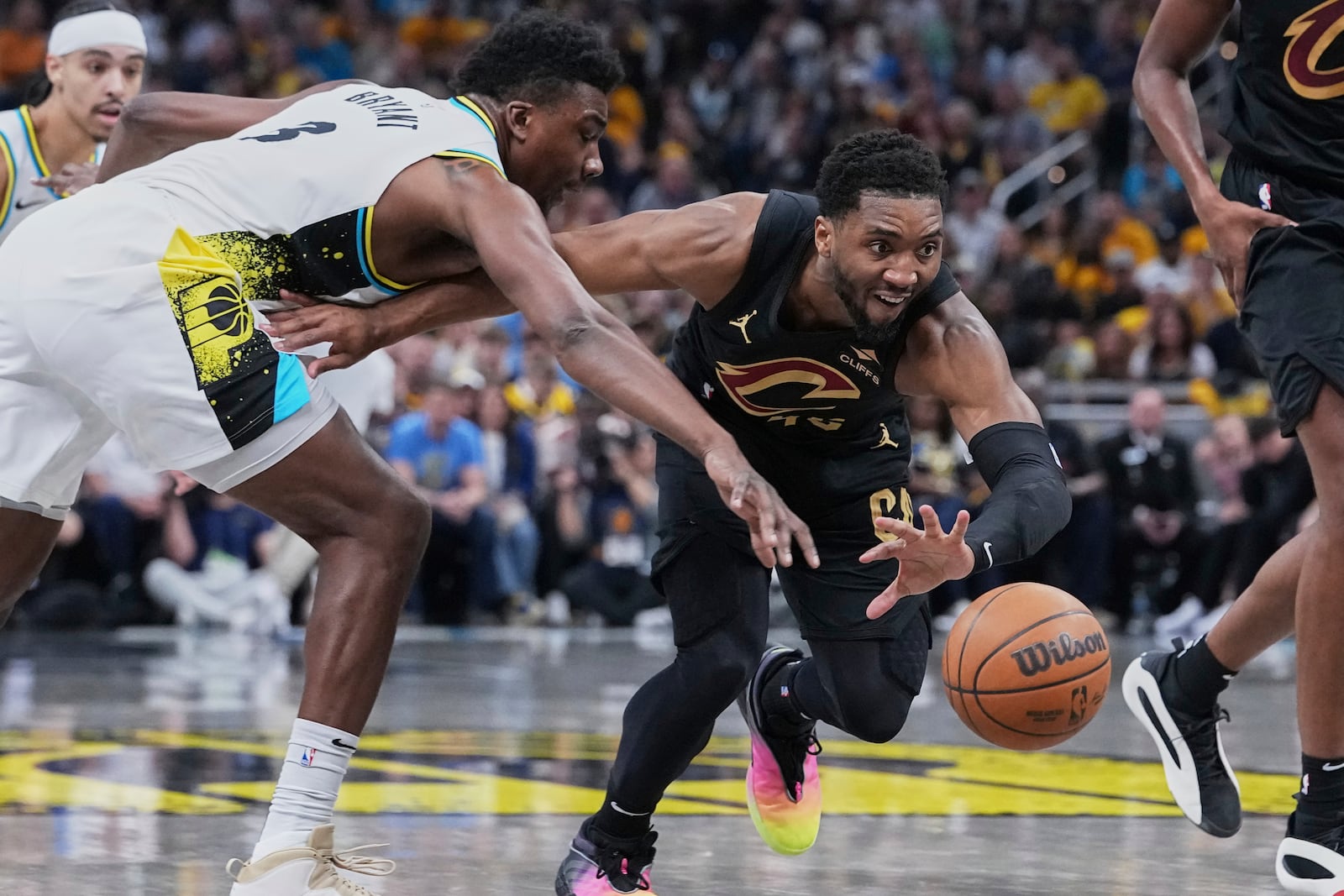 Cleveland Cavaliers guard Donovan Mitchell (45) chases down the ball against Indiana Pacers center Thomas Bryant (3) in the first half of Game 4 in the Eastern Conference semifinals of the NBA basketball playoffs in Indianapolis, Sunday, May 11, 2025. (AP Photo/Michael Conroy)