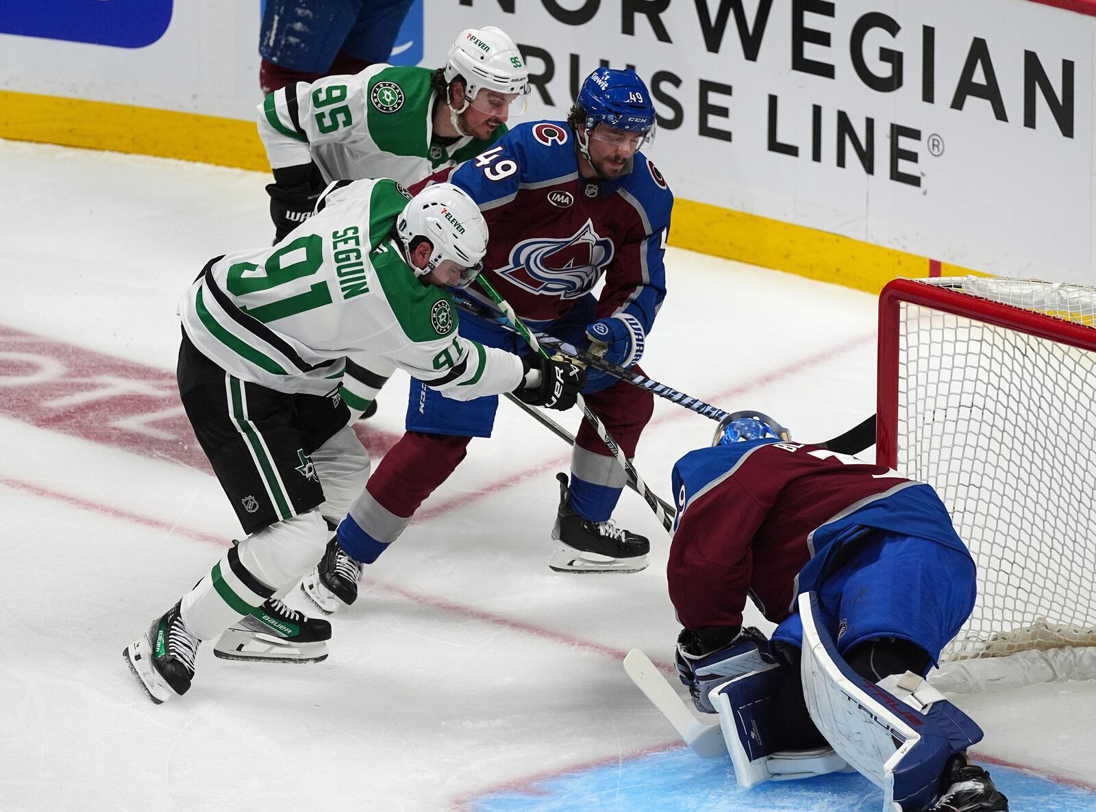 Dallas Stars center Tyler Seguin, front left, puts a shot on Colorado Avalanche goaltender Mackenzie Blackwood, front right, as defenseman Samuel Girard, back right, blocks Dallas center Matt Duchene in the first period of Game 3 of an NHL hockey first-round playoff series Wednesday, April 23, 2025, in Denver. (AP Photo/David Zalubowski)