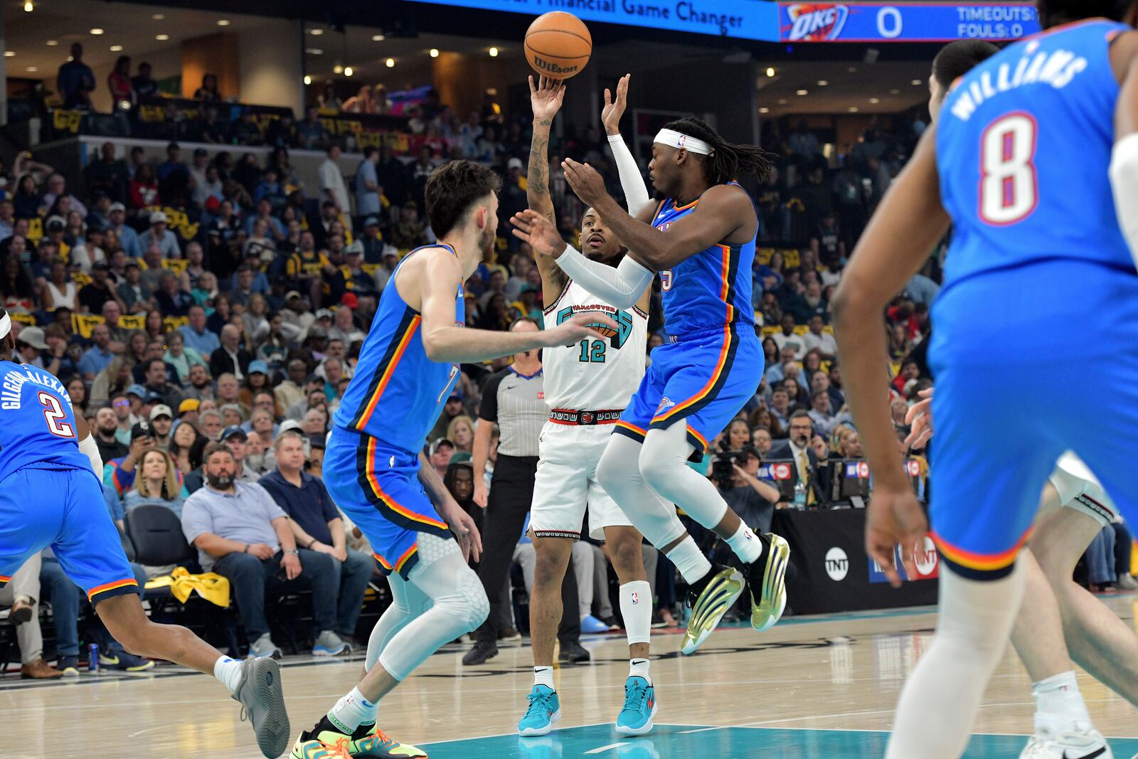 Memphis Grizzlies guard Ja Morant (12) shoots between Oklahoma City Thunder guard Luguentz Dort (5) and forward Chet Holmgren, center left, in the first half of Game 3 of an NBA first-round playoff series Thursday, April 24, 2025, in Memphis, Tenn. (AP Photo/Brandon Dill)