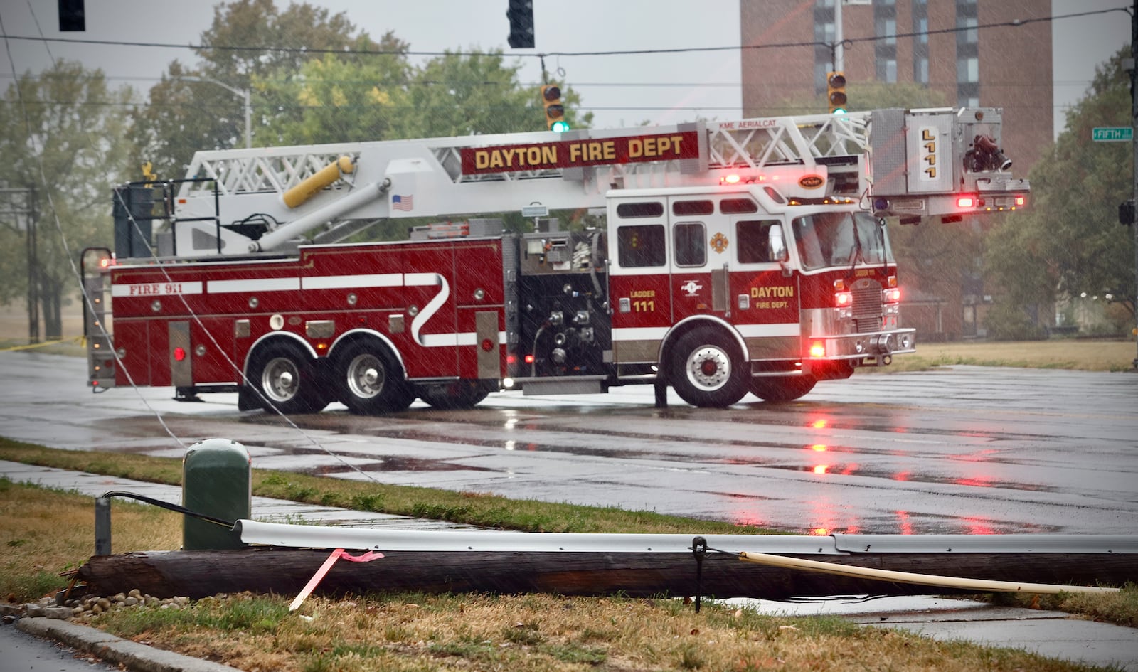 A Dayton Fire Department ladder truck blocks South Keowee and East Fifth streets due to a utility pole and power lines across the roadway Friday, Sept. 27, 2024, in Dayton. MARSHALL GORBY\STAFF