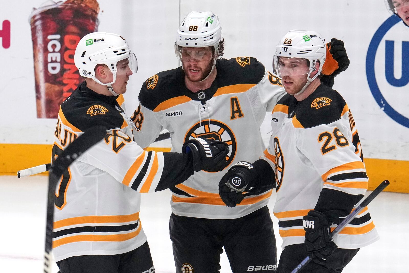 Boston Bruins' Elias Lindholm (28) celebrates his goal with David Pastrnak (88) and Henri Jokiharju during the first period of an NHL hockey game against the Pittsburgh Penguins in Pittsburgh, Sunday, April 13, 2025. (AP Photo/Gene J. Puskar)