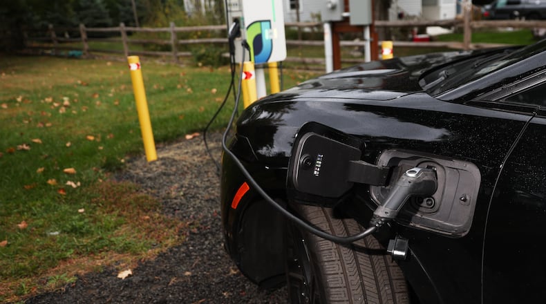 FILE - Daphne Dixon's electric vehicle is plugged into a Level 2 EV charger Oct. 11, 2025, in Norwalk, Conn. (AP Photo/Heather Khalifa, File)