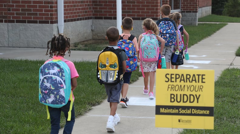 Students practice social distancing as they walked into Simon Kenton in August for the first day of school. The district will once again be offering in-person and virtual learning options for the second semester. BILL LACKEY/STAFF