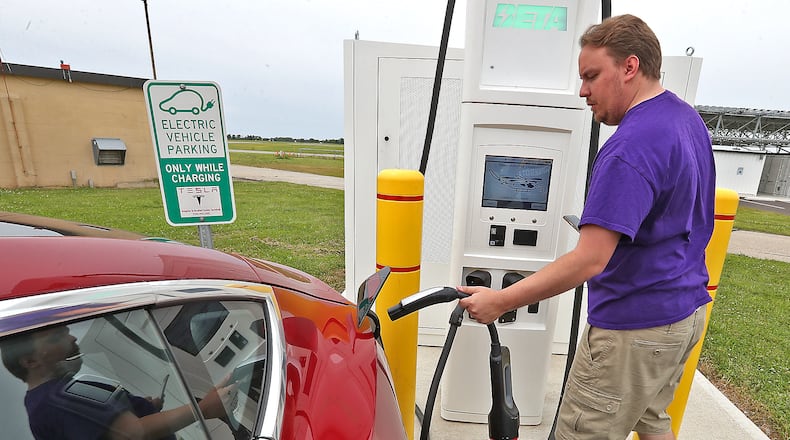 Austin Eggers plugs in his Tesla electric car at the charging station at Springfield Beckley Municipal Airport Friday, June 10, 2022. BILL LACKEY/STAFF
