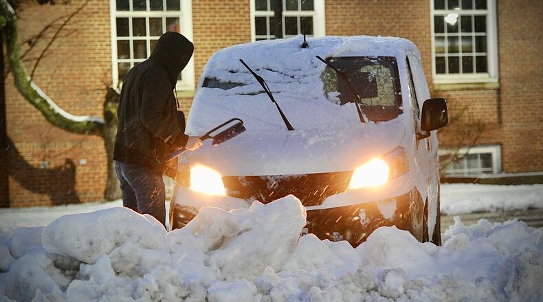 A Fairborn resident remove snow from his vehicle in downtown Fairborn early Wednesday morning, January 25, 2023 MARSHALL GORBY\STAFF