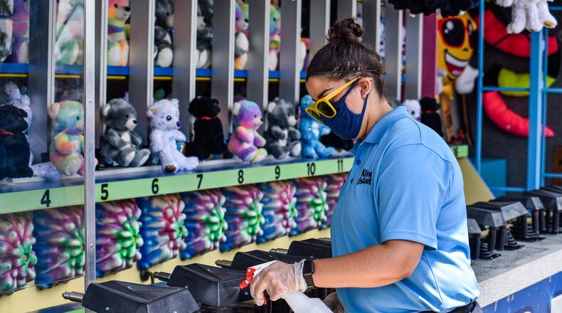 Kings Island opens to pass holders July 2 with numerous protocols in place to decrease the chance of spread of COVID-19. Guest must pre-register for admission to the park and are required to wear masks, get their temperature taken and stand in accordance with social distancing guidelines. There are also hundreds of hand sanitizers stations around the park and staff cleaning rides, games, restaurants and touch surfaces regularly. NICK GRAHAM / STAFF