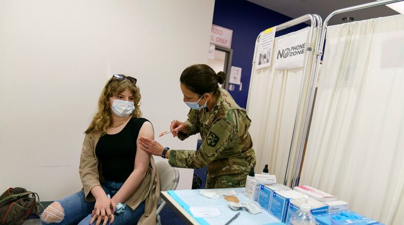 Lillian Ranney, 12, left, receives her first dose of the Pfizer COVID-19 vaccine from Rhode Island Air Force National Guard Lt. Col. Barbara Webster at a mass vaccination site at the former Citizens Bank headquarters in Cranston, R.I., Thursday, May 13, 2021. (AP Photo/David Goldman)