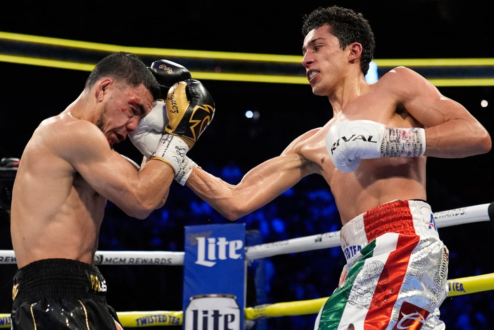 Rafael Espinoza hits Edward Vazquez in a featherweight title boxing match Sunday, May 4, 2025, in Las Vegas. (AP Photo/John Locher)