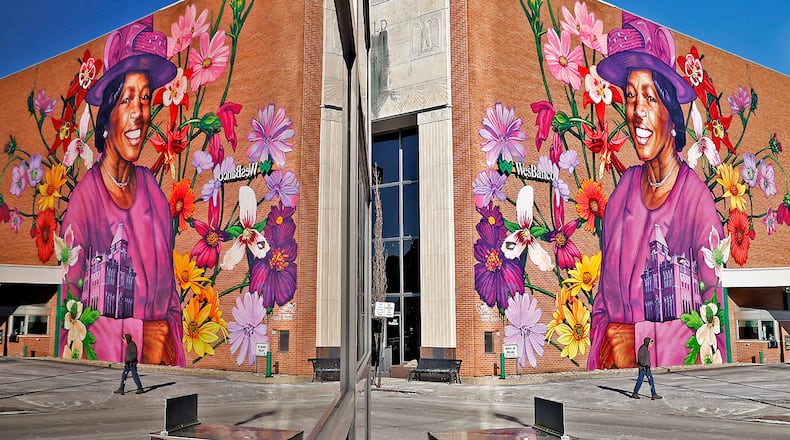 The mural of Hattie Moseley is reflected in the window of the building across the street Thursday, Feb. 2, 2023, along Main Street in Springfield. Moseley, a civil rights advocate, is the city's newest piece of public art. BILL LACKEY/STAFF