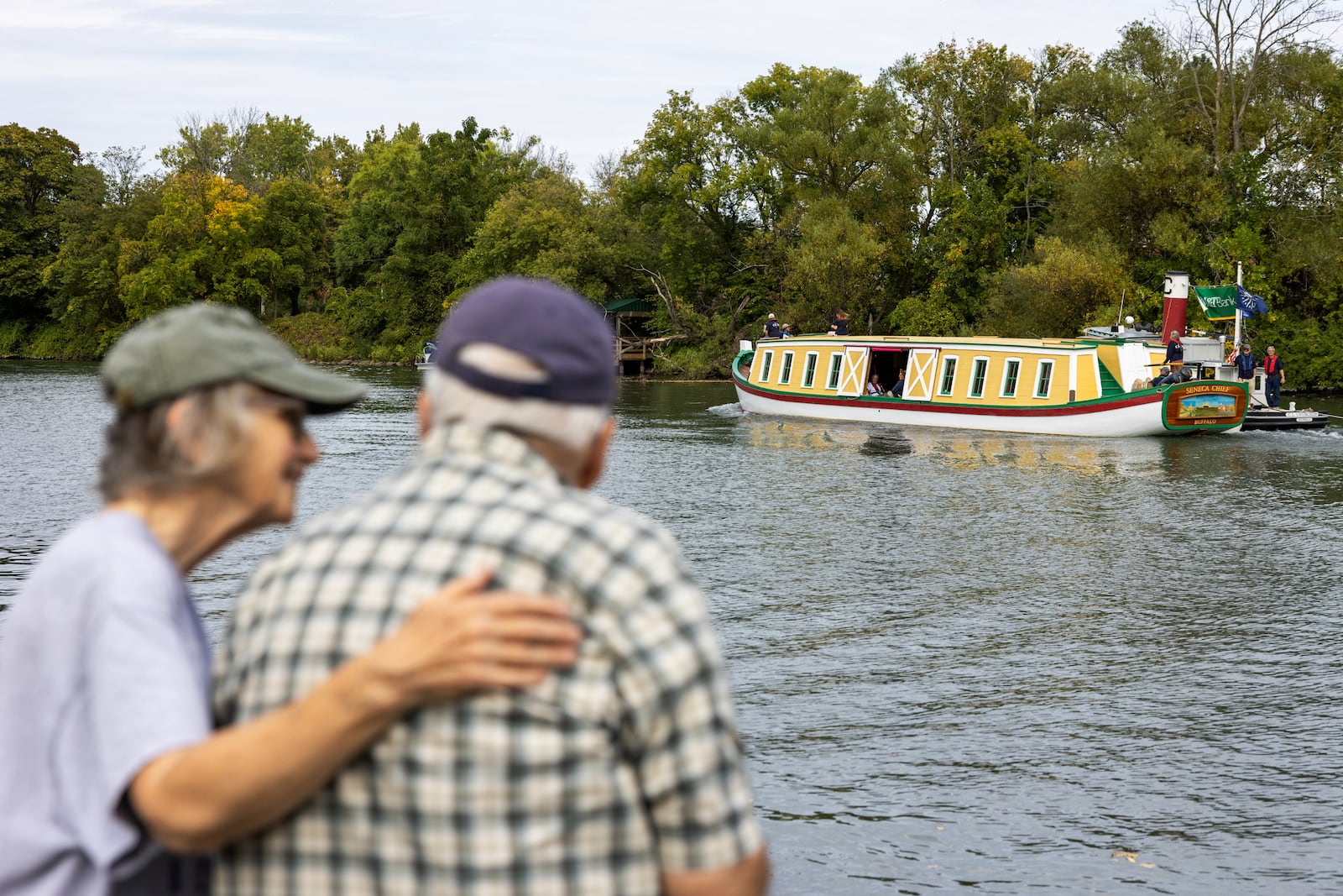 People watch a replica of the Seneca Chief, the first boat to traverse the newly opened Erie Canal in 1825, passes Tonawanda N.Y., on its way to New York City, Sept. 24, 2025. As the 200th anniversary of the Erie Canal approaches on Oct. 26, organizers are seeking to temper the celebration with an acknowledgment of the waterway’s dispossession of Native American communities. (Lauren Petracca/The New York Times)