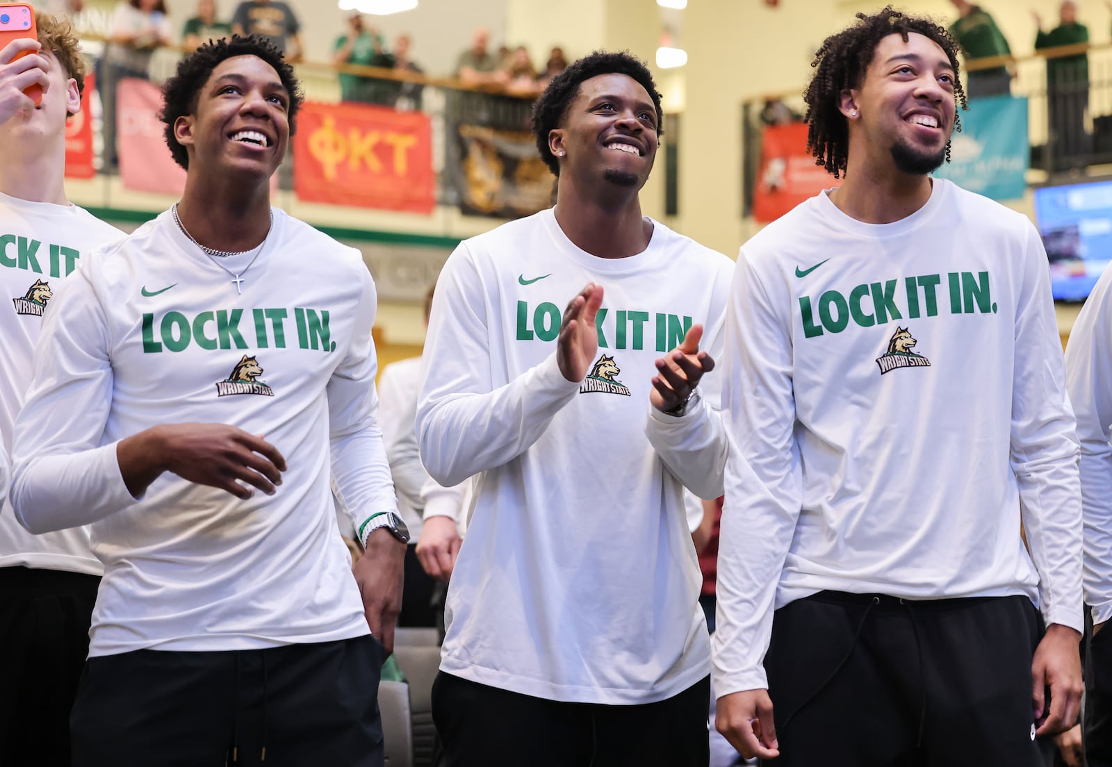 From left to right, Wright State's Solomon Callaghan, Sam Alamutu and Logan Woods celebrate after Wright State's NCAA tournament seed and opponent were announced during a Selection Sunday watch party on Sunday, March 15 at the university's Student Union in Fairborn. BRYANT BILLING / STAFF
