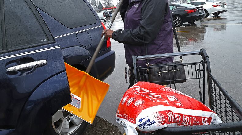 Tandra Thompson loads a new snow shovel and some rock salt into her car Wednesday in the parking lot of Handyman ACE Hardware as she prepares for the winter storm that's forecast for Thursday. BILL LACKEY/STAFF