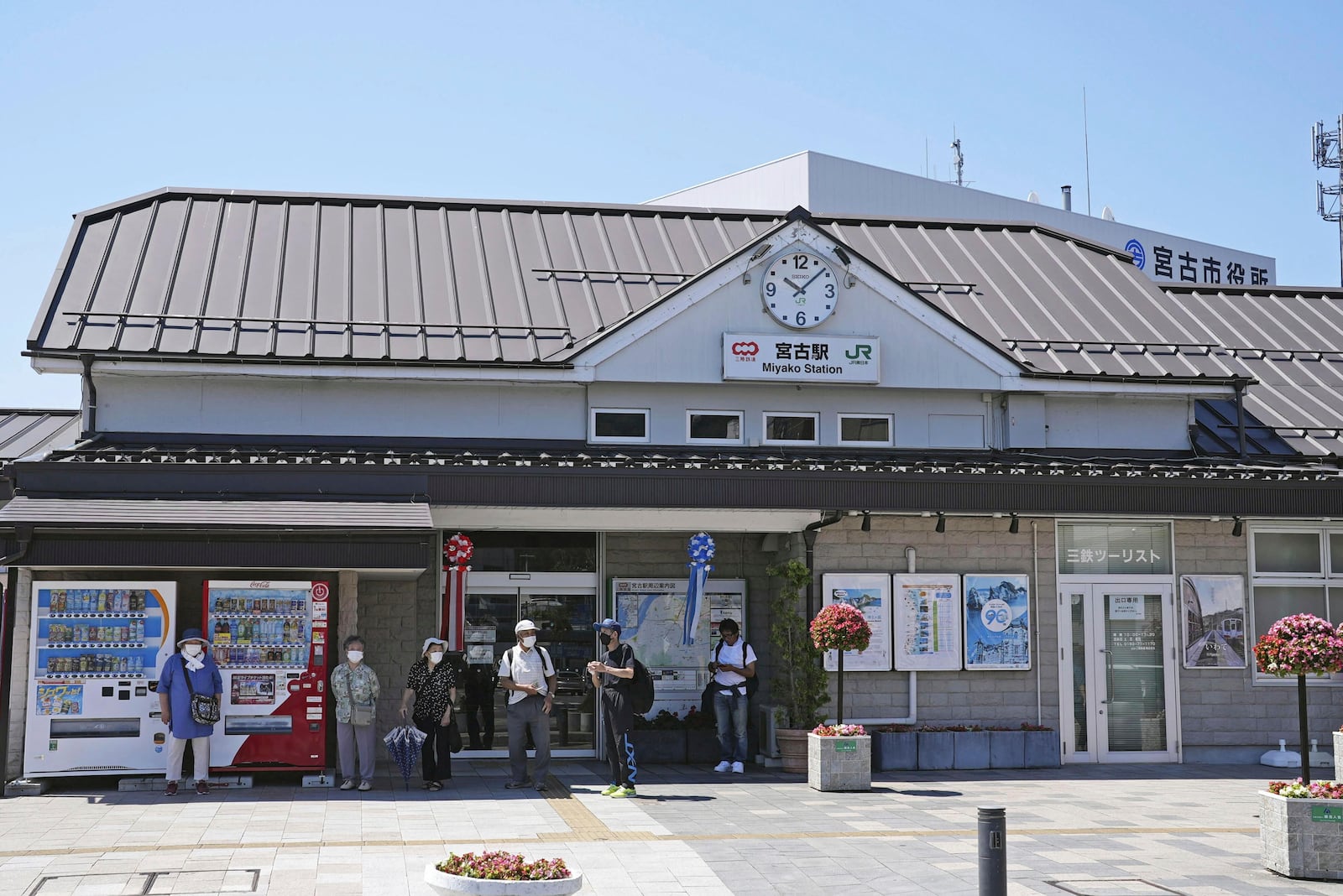 Passengers stand in front of a staion in Miyako, Iwate prefecture, northern Japan Wednesday, July 30, 2025 as train services were suspended due to a tsunami alert following a powerful earthquake in Russia's Far East. (Yohei Kanesashi/Kyodo News via AP)