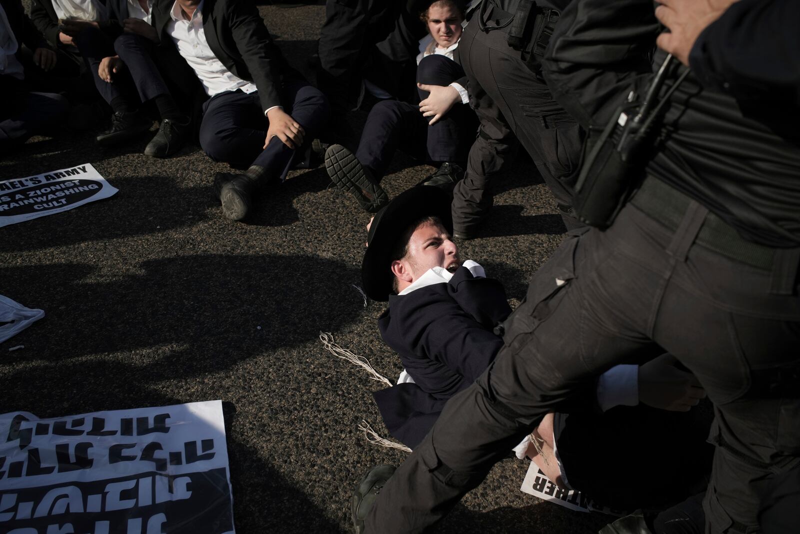 Israeli police officers disperse ultra-Orthodox Jewish men during a protest against army recruitment in Bnei Brak, Israel, Thursday, June 5, 2025. (AP Photo/Leo Correa)
