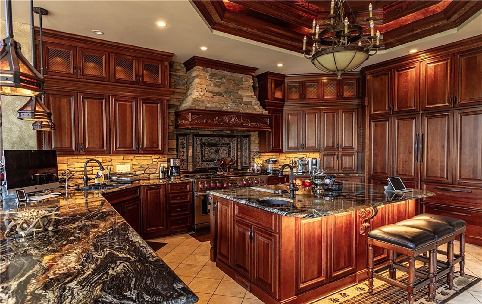 The kitchen has custom cabinetry with granite tops, an island with bar seating and a sink and high end appliances, including a professional gas range. CONTRIBUTED