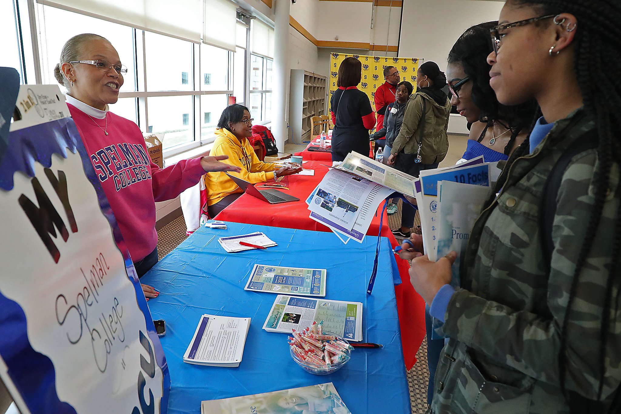 Springfield High School students Imani Fudge, left, and Nija Brown talk with Shannon Moore from Spelman College Friday during the HBCU Day at the school. BILL LACKEY/STAFF