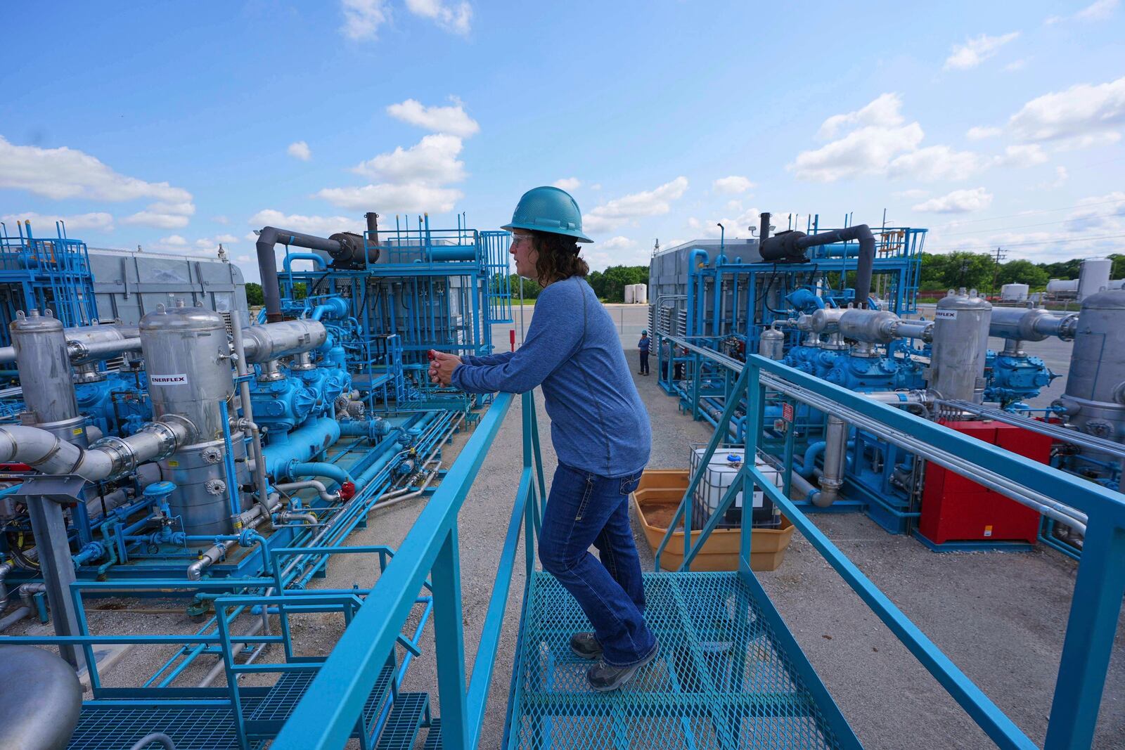 BKV Carbon Ventures senior facility engineer Laura Mamazza stands near part of a compression station at a carbon capture and sequestration facility in Bridgeport, Texas, Thursday, May 29, 2025. (AP Photo/LM Otero)