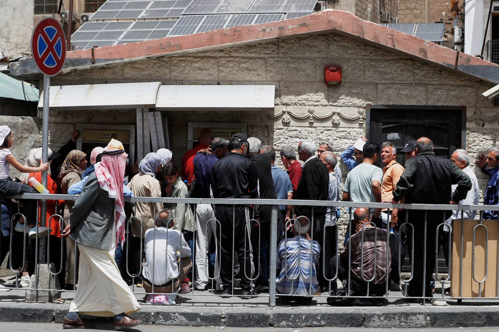 Syrians line up to retrieve money from an ATM in Damascus, Syria, Wednesday, May 14, 2025. (AP Photo/Omar Sanadiki)