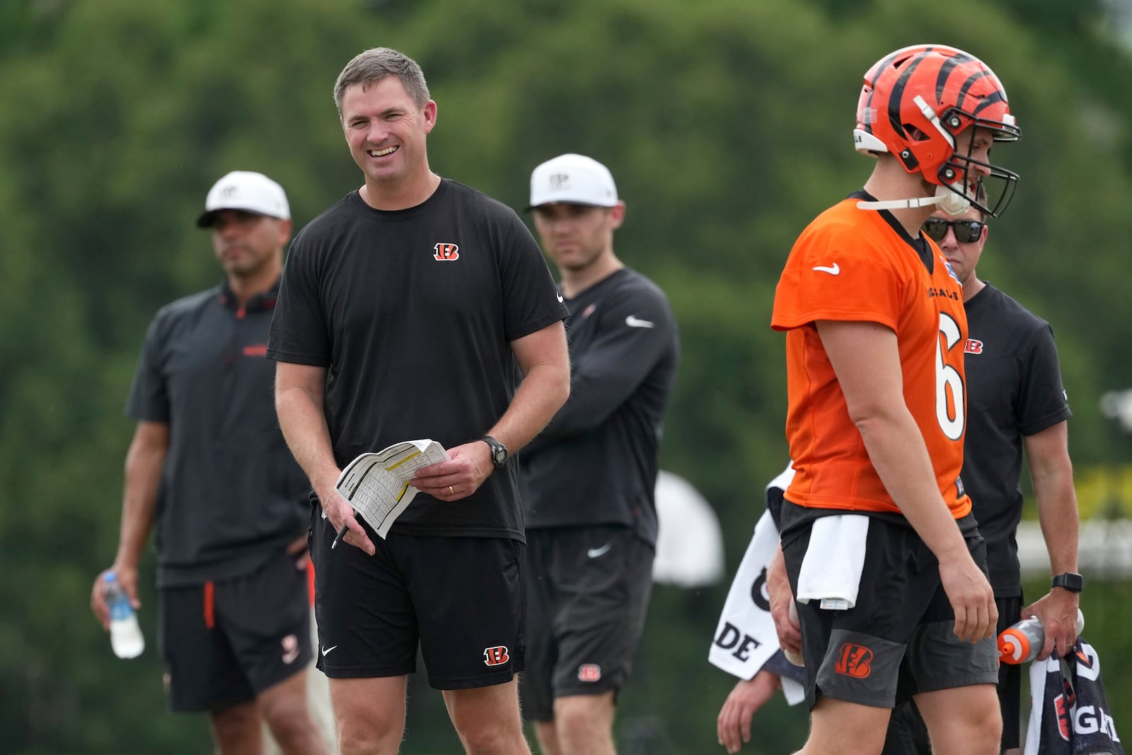 Cincinnati Bengals head coach Zac Taylor, left, shares a laugh with quarterback Jake Browning (6), right, during NFL football practice Tuesday, June 3, 2025, in Cincinnati. (AP Photo/Kareem Elgazzar)