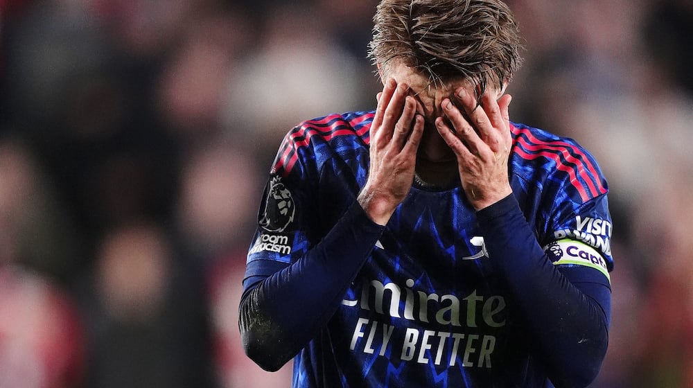 Arsenal's Martin Odegaard reacts after getting injured attempting to prevent Brentford's Keane Lewis-Potter from scoring during the English Premier League soccer match between Brentford and Arsenal in London, Thursday, Feb. 12, 2026. (John Walton/PA via AP)