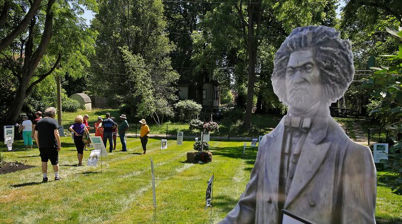 A lifesize cutout of Fredrick Douglas greets visitors at the end of the Discovery Walk through the Underground Railroad safe houses and secret codes along Route 68 from the Ohio River to Lake Erie behind the Gammon House Saturday, June 15, 2024 during the annual Juneteenth and Fatherfest Celebration. BILL LACKEY/STAFF