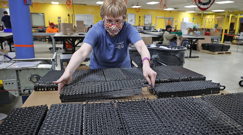 Donnette Laymen, an employee of The Abilities Connection places carts on a pallet after they've been sorted Tuesday. BILL LACKEY/STAFF