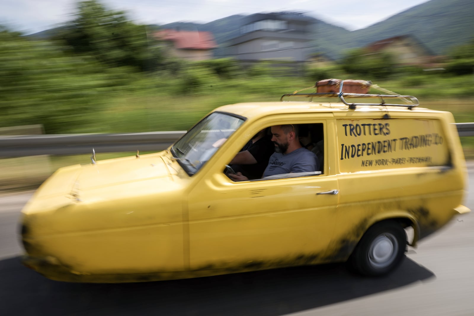 Tarik Fatic along with his brother Mirnes drives the Reliant Regal, an exact copy of the famous BBC TV show "Only Fools and Horses" iconic yellow car in Sarajevo, Bosnia, Wednesday, June 4, 2025. (AP Photo/Armin Durgut)