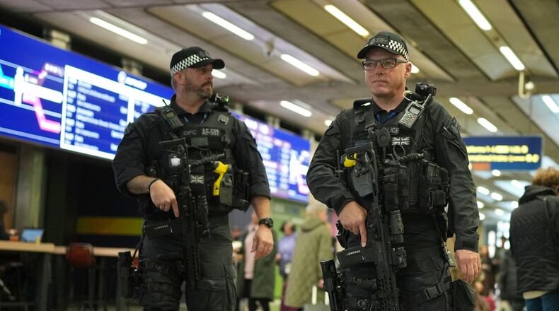Armed police officers patrol the St Pancras International train station, in London, England, Monday, Nov. 3, 2025. (AP Photo/Kin Cheung)