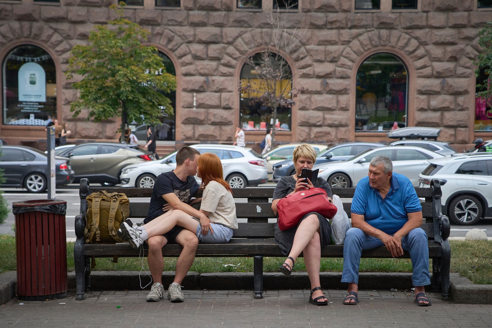 People rest on a bench in central Kyiv, Ukraine, Wednesday, July 9, 2025. (AP Photo/Efrem Lukatsky)