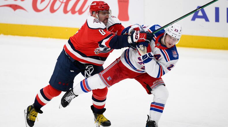 Washington Capitals left wing Alex Ovechkin (8) battles with New York Rangers defenseman Adam Fox (23) during the third period of an NHL hockey game, Wednesday, Dec. 31, 2025, in Washington. (AP Photo/Nick Wass)