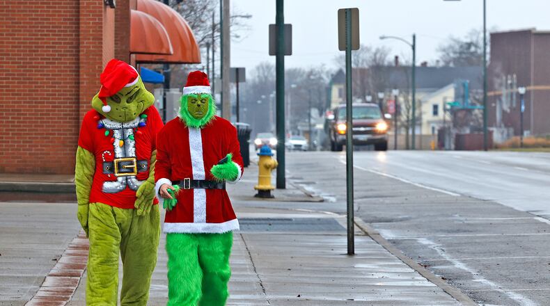 A couple of Grinches were walking along a wet High Street in Springfield Friday, Dec. 20, 2024. The Grinches were actually Elijah Parsons, left, and Jeremy Byron who said they were just trying to spread a little Christmas joy. BILL LACKEY/STAFF