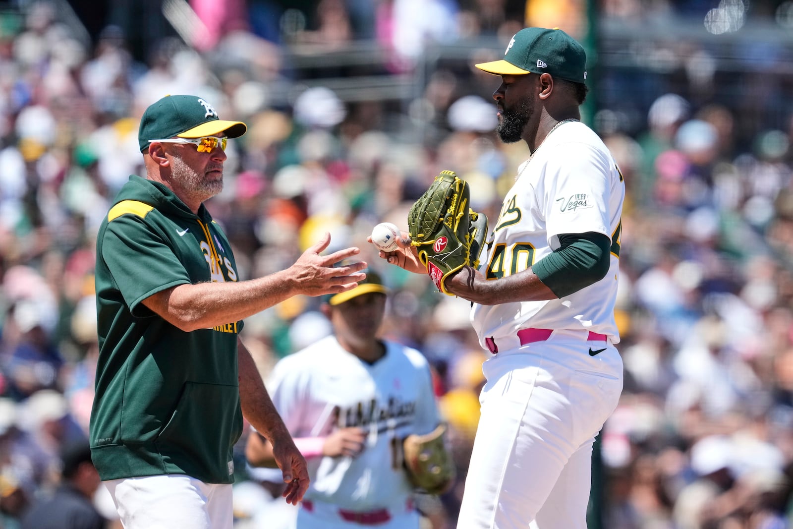 Athletics pitcher Luis Severino, right, hands the ball over to manager Mark Kotsay, left, was he exits during the fifth inning of a baseball game against the New York Yankees, Sunday, May 11, 2025, in West Sacramento, Calif. (AP Photo/Godofredo A. Vásquez)