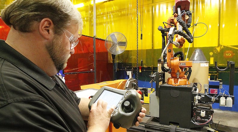 Craig Cornell, an employee at Cascade, operates one of the company’s robots Thursday, July 6, 2017. Bill Lackey/Staff