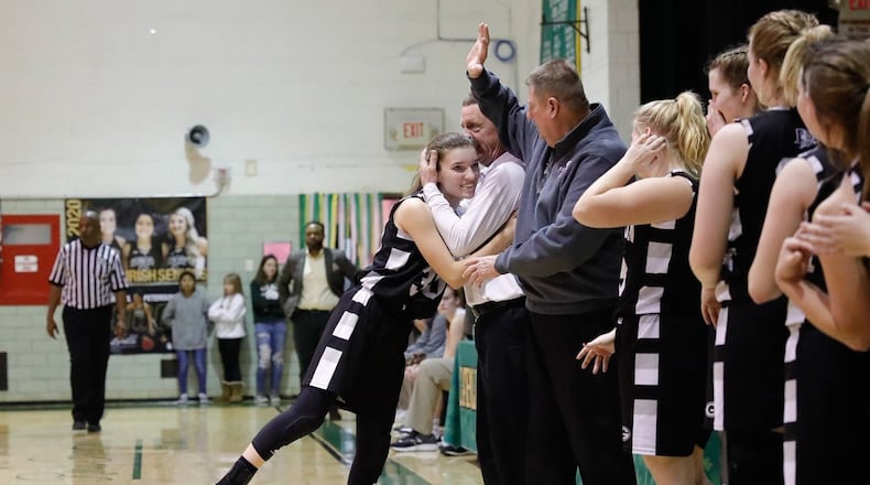 Greenon High School senior Reagan Ware is hugged by Knights coach Lonnie Robinson as leaves the floor during their game against Catholic Central High School on Saturday night at Jason Collier Gymnasium. Ware scored 13 of her game-high 20 points in the fourth quarter and overtime as the Knights beat Central 62-52 in OT to win the Ohio Heritage Conference South Division title. CONTRIBUTED PHOTO BY MICHAEL COOPER
