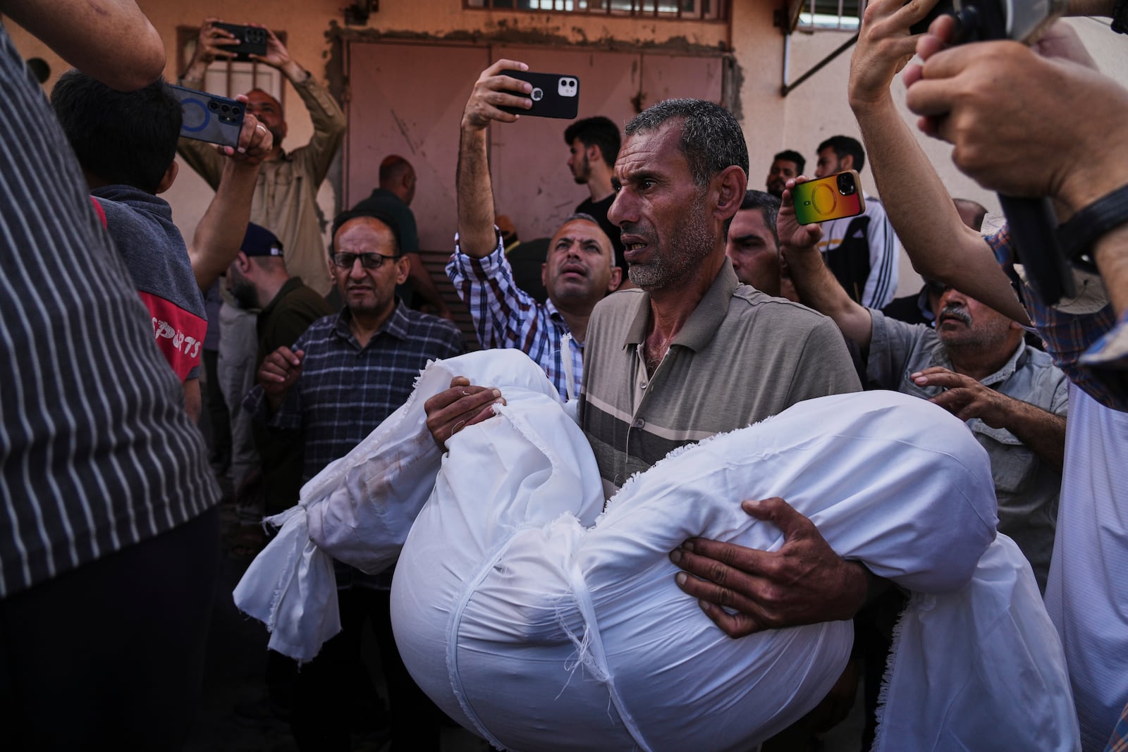 Mohammad Nassar carries the body of his nephew Jana Nassar killed in an Israeli army airstrike on the Gaza Strip, during his funeral at Al-Aqsa Hospital in Deir al-Balah, Gaza, Tuesday, May 20, 2025. (AP Photo/Abdel Kareem Hana)