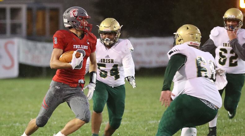 Southeastern’s Charlie Bertemes tries to avoid tackles from Catholic Central’s Hasim Muhammad, left, Paul Kuss-Shivler, center, and Robbie Walker. BILL LACKEY/STAFF