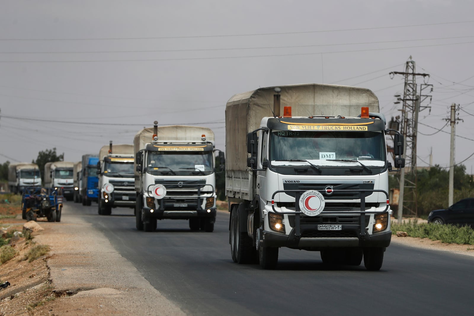 A convoy of vehicles loaded with food and other aid is en route to Sweida on the international highway in rural Daraa province, Syria, Sunday, July 20, 2025, heading to the city of Busra al-Sham. (AP Photo/Omar Sanadiki)