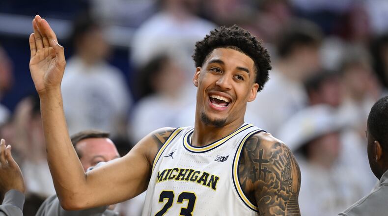 Michigan forward Yaxel Lendeborg (23) smiles as he celebrates with his teammates in the waning seconds of their win over UCLA in an NCAA college basketball game in Ann Arbor, Mich., Saturday, Feb. 14, 2026. (AP Photo/Lon Horwedel)
