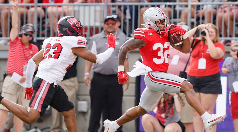 Ohio State running back TreVeyon Henderson, right, runs past Western Kentucky linebacker Rashion Hodge to score a touchdown during the first half of an NCAA college football game, Saturday, Sept. 16, 2023, in Columbus, Ohio. (AP Photo/Jay LaPrete)