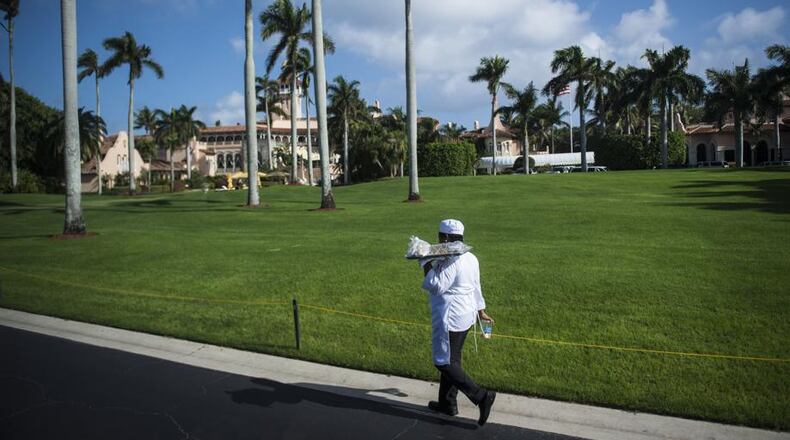 A worker walks the driveway along Mar-a-Lago,  the club and estate owned by President Donald Trump, located in Palm Springs, Florida.